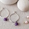 Silver hoop earrings with amethysts and pearl charms. You may change the charms and have different earrings in one piece!